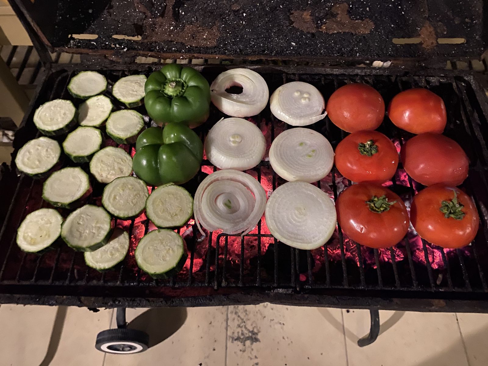 Parrilla con zapallo italiano, pimentón, cebolla y tomates sobre brasas.